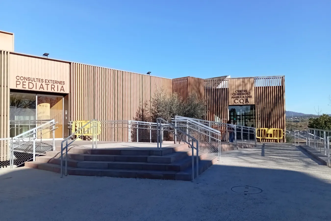 Espacio exterior de acceso a hospital con revestimiento sostenible VISENDUM®, diseñado para movilidad reducida y entornos urbanos saludables.