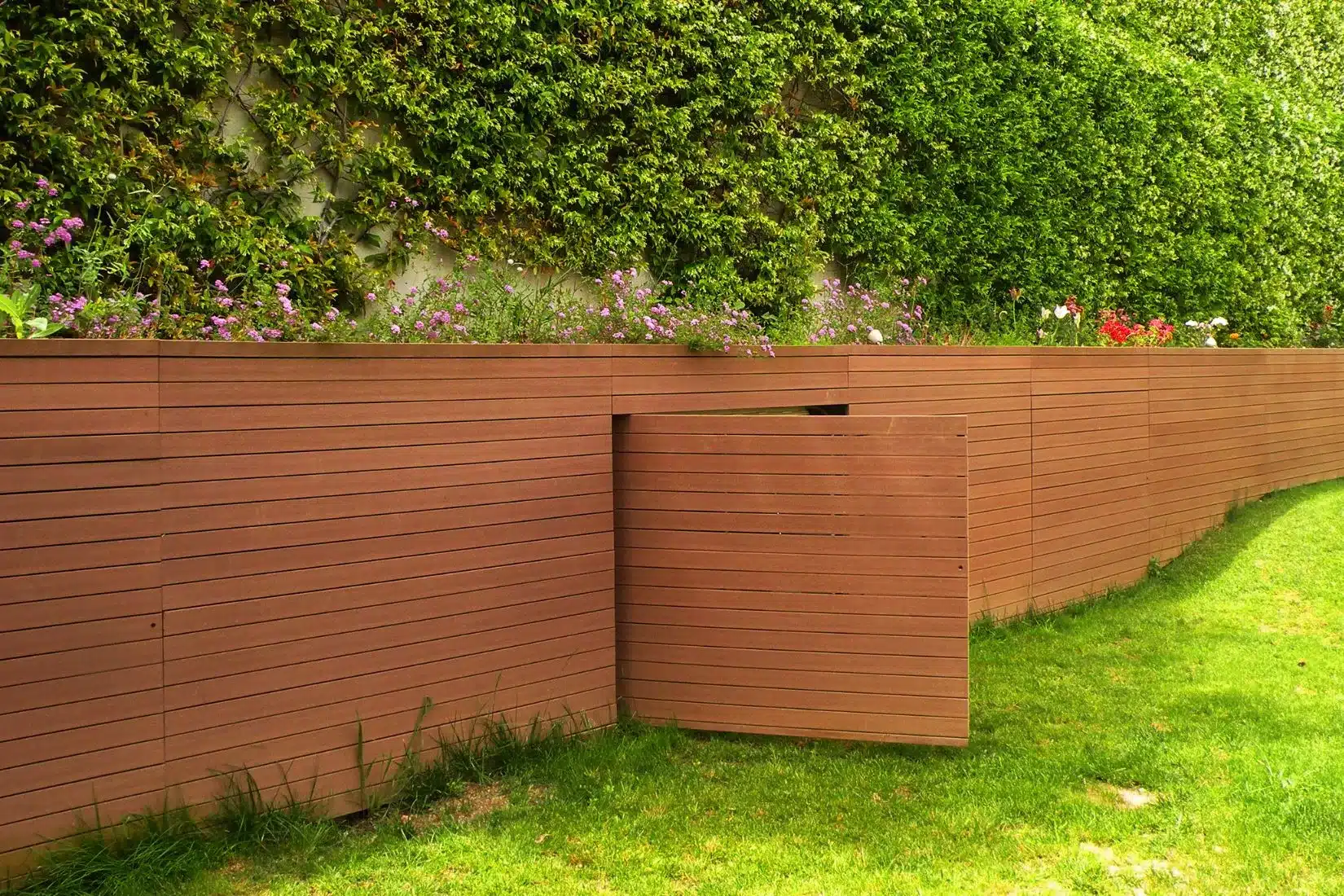 Fachada moderna con madera tecnológica VISENDUM® y muro ajardinado vertical