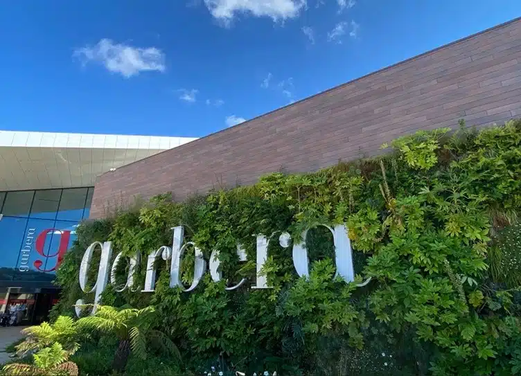 Jardín vertical con vegetación natural y tarima exterior VISENDUM® en diseño sostenible