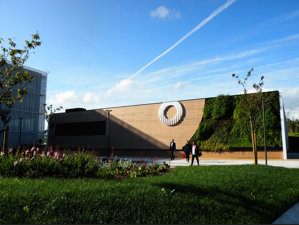 Muro exterior con tarima tecnológica VISENDUM® y jardín vertical integrado en entorno moderno
